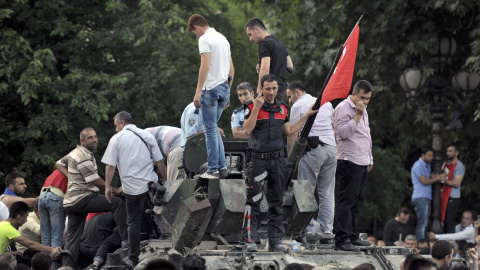Un policía turco y varios civiles sobre de un vehículo militar en Ankara, tras el intento de golpe de Estado militar en Turquía.- REUTERS