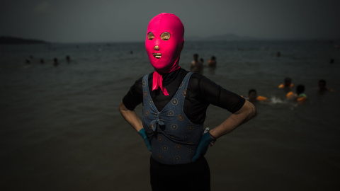 Una mujer posa con un facekini en la playa en Qingdao, provincia oriental china de Shandong. AFP PHOTO / FRED DUFOUR