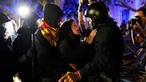 Una manifestante media ante un agente durante las protestas junto al Parlament. - REUTERS