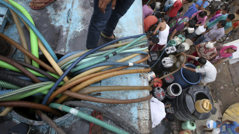 Varias personas rellenan cubos de agua de un camión cisterna en Nueva Delhi, India hoy 30 de julio de 2015. Según fuentes oficiales un 20 por ciento de la población de Nueva Delhi no tiene acceso al agua y se encuentran obligados a recolect