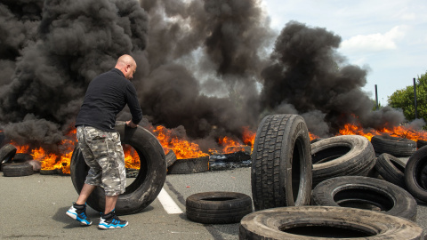 Los empleados de la empresa My Ferry Link bloquean el acceso al puerto con neumáticos en llamas durante la huelga el 31 de julio de 2015, en Calais, al norte de Francia, tras el fracaso de las negociaciones con el gobierno francés en relaci