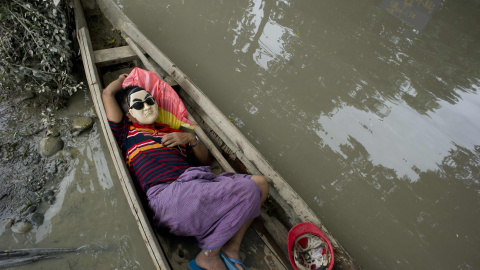 Un residente descansa en una barca junto en las aguas de Kalay, en la región de Sagaing de Myanmar, el 3 de agosto de 2015. Las lluvias monzónicas han provocado inundaciones repentinas y deslizamientos de tierra, destruyendo miles de casas,