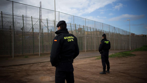 Imagen de archivo de dos agentes de la Guardia Civil junto a la valla de Melilla. Imagen de archivo de dos agentes de la Guardia Civil junto a la valla de Melilla.