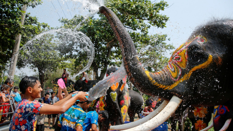 Un niño y un elefante se salpican el uno al otro con agua durante la celebración del festival de Songkran en la provincia de Ayutthaya de Tailandia. REUTERS/Jorge Silva