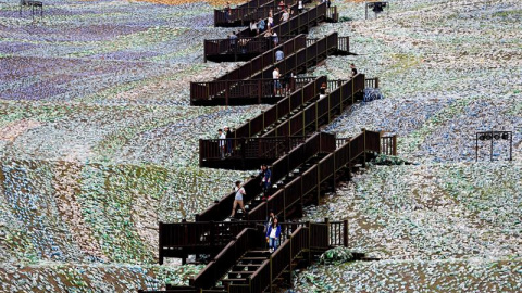 Varias personas pasean por el mosaico que representa 'La noche estrellada' del pintor holandés Vincent Van Gogh y que ha sido reconstruido con botellas de plástico desechadas en Keelung (Taiwán). EFE/Ritchie B. Tongo