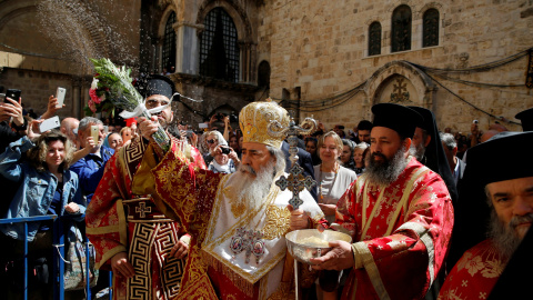 El patriarca griego ortodoxo Theophilos bendice a la multitud durante la ceremonia del 'Lavapiés' fuera de la Iglesia del Sagrado Sepulcro en la ciudad vieja de Jerusalén. REUTERS/Ammar Awad