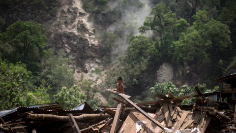 Un niño limpia aparta escombros entre las ruinas de su casa, tras el terremoto del martes en Singati Village, en Dolakha (Nepal).- ATHIT PERAWONGMETHA (REUTERS)