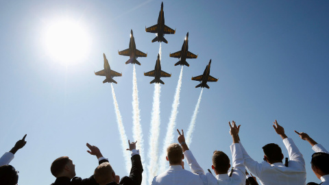 Guardiamarinas miran hacia el cielo mientras los US Navy Blue Angels realizan una pasada con sus cazas para comenzar la ceremonia de graduación en la Academia Naval de EEUU en Annapolis. Maryland.- KEVIN LAMARQUE (REUTERS)
