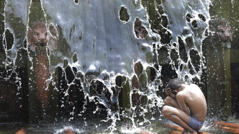 Un niño juega en una fuente durante un caluroso día de verano en Nueva Delhi. EFE/Harish Tyagi