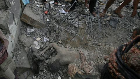 El cuerpo de un hombre, bajo los escombros de un edificio descuido por un ataque aéreo saudita en la ciudad de Taiz en Yemen.- REUTERS/STR