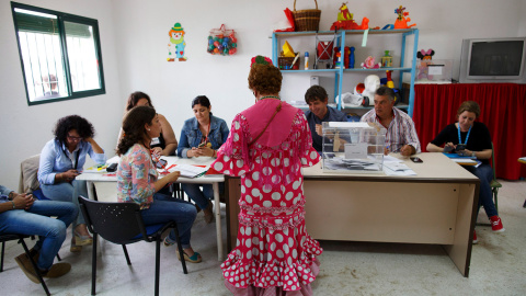 Una mujer vestida con el traje tradicional de rociera, en un colegio electoral, durante las elecciones del 24-M en El Rocío.- MARCELO DEL POZO (REUTERS)