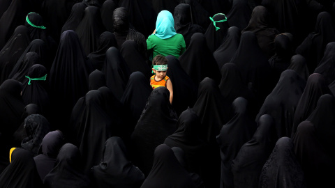 Un niño mira a su alrededor mientras decenas de dolientes iraníes acuden al funeral de Mohammad Hamidi, Hasan Ghafari y Ali Amrai, miembros de la Guardia Revolucionaria de la República Islámica.- ATTA KENARE (AFP)