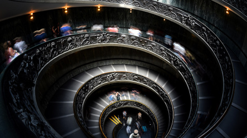 Visitantes recorren las escaleras de los Museos Vaticanos diseñadas por Giusepe Momo en 1932.- GABRIEL BOUYS (AFP)