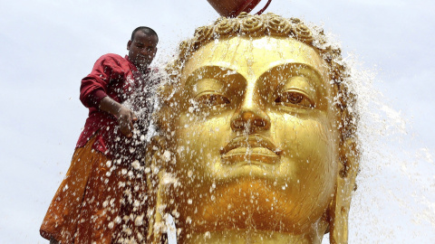 Un monje budista limpia una estatua de Buda de cara a las celebraciones de su cumpleaños en un monasterio de Bhopal. EFE/Sanjeev Gupta