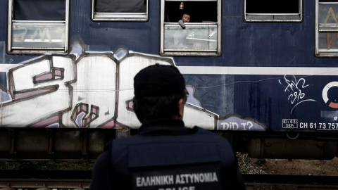 Un niño se asoma a la ventana de un vagón de tren durante una operación para desalojar el campamento improvisado de Idomeni, en Greci. EFE/Yannis Kolesidis