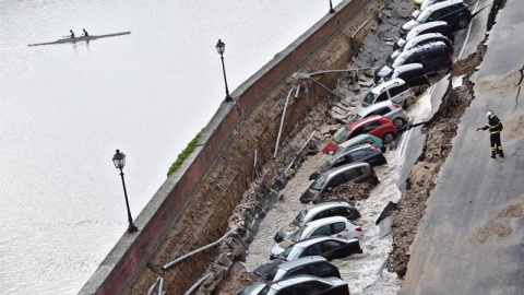 Varios vehículos aparecen engullidos por un socavón cerca del famoso Puente Viejo a orillas del río Arno, en el centro de la ciudad italiana de Florencia (Italia). EFE/Maurizio Degl' Innocenti