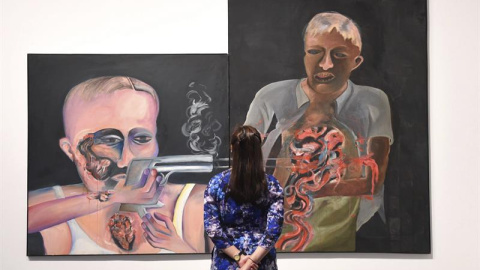 Una trabajadora del museo observa la obra 'Bullet Shot in the Stomach', del artista indio Bhupen Khakhar, durante la presentación a la prensa de la exposición 'You Can't Please All' en el museo Tate Modern de Londres, Reino Unido. EFE/Facun
