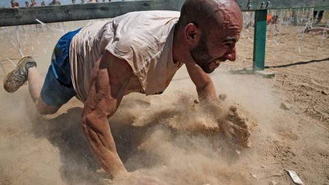Uno de los participantes durante la 'Mud Day Race', la carrera de obstáculos que ha tenido lugar en la base militar de El Goloso, a las afueras de Madrid. REUTERS/Juan Medina