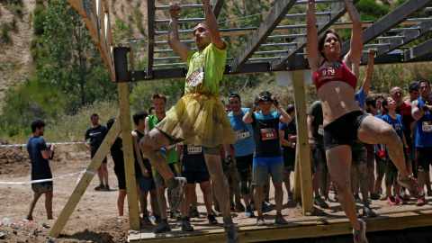 Dos de los participantes durante la 'Mud Day Race', la carrera de obstáculos que ha tenido lugar en la base militar de El Goloso, a las afueras de Madrid. REUTERS/Juan Medina
