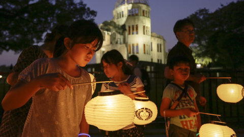 Varios niños de Hiroshima llevan linternas durante una procesión en honor a las víctimas de la bomba atómica ante la Cúpula de la Bomba Atómica, en el Parque Conmemorativo de la Paz de Hiroshima, en el oeste de Japón, hoy, 5 de agosto de 20