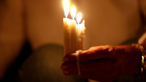 Una mujer enciende velas durante una vigilia en solidaridad con los soldados jordanos asesinados en un ataque contra un puesto militar fronterizo cerca de un campamento de refugiados sirios, en Amman. REUTERS/Muhammad Hamed