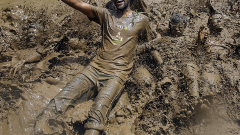 Estudiantes nepalíes del colegio agrícola del Himalaya se zambullen en un charo de barro para celebrar el Día Nacional del Arroz en la población de Badegaun, en Nepal. EFE/Narendra Shrestha
