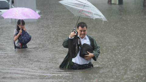 Un hombre lleva su paragüas mientras atravisa la calle entre las aguas a causa de las inundaciones en Taiyuan, en la provincia de Shanxi Province, China. China Daily/REUTERS