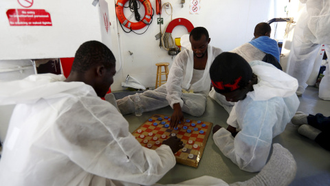 Un grupo de inmigrantes rescatados del Mediterráneo se entretiene jugando en uno de los barcos de la Guardia Costera de camino a Lampedusa. REUTERS/Darrin Zammit Lupi