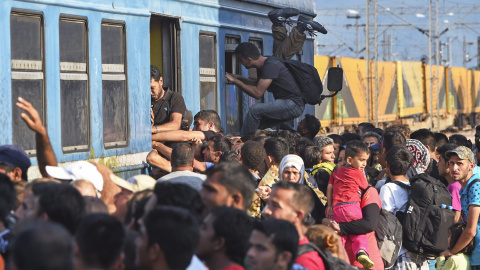 Cientos de personas se agolpan para ocupar una de las plazas de los vagones del tren que parte de la localidad de Gevgelija, Macedonia, junto a la frontera con Serbia. EFE/Georgi Licovski