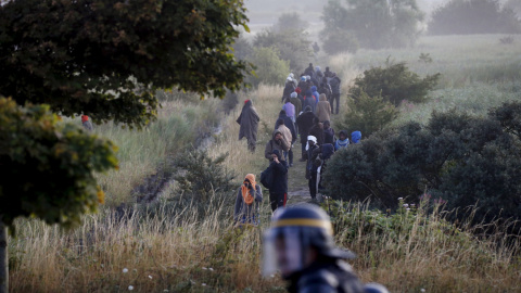 Un grupo de inmigrantes que intentaba alcanzar el eurotúnel son interceptados por la Policía en Calais, Francia. crisis. REUTERS/Pascal Rossignol