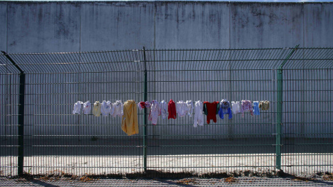 Varias prendas cuelgan de la valla del centro temporal para inmigrantes de Ingelheim, en Alemania. REUTERS/Ralph Orlowski