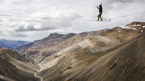 Fotografía facilitada hoy, 6 de agosto de 2015, que muestra al funambulista Bence Kerekes, miembro de un equipo húngaro de deportes de riesgo, mientras camina sobre un cable de 32 metros a una altura de 5.322 metros sobre la cadena montaños
