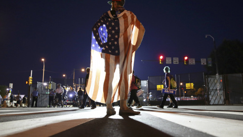 Un partidario del ex candidato presidencial demócrata, el senador Bernie Sanders, viste a modo de capa una bandera de Estados Unidos cerca del Centro de Wells Fargo en Filadelfia. REUTERS/Dominick Reuter.
