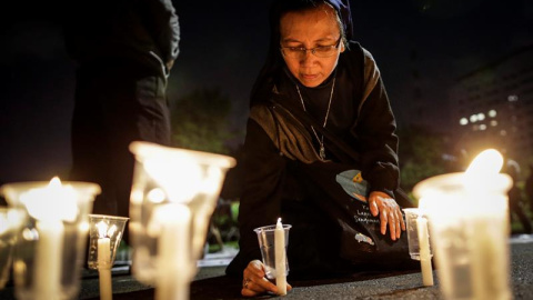 Una monja indonesia enciende una vela durante una vigilia de protesta contra la pena de muerte delante del Palacio Presidencial en Yakarta (Indonesia). EFE/Mast Irham