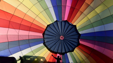 Miembros de la tripulación inflan un globo durante un lanzamiento masivo en la fiesta Internacional de Globos en Bristol, en el suroeste de Inglaterra, 7 de agosto de 2015. El festival de globos de aire caliente más grande de Europa cumple 