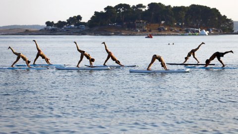 Varias personas practican una modalidad de Yoga en la costa adriática en Medulin, Croacia. REUTERS / Pawel Kopczynski