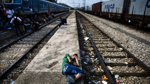 Un inmigrante descansa sobre una plataforma en la estación de tren en Gevgelija. Muchos inmigrantes tratan de cruzar Macedonia y Serbia para entrar en la Unión Europea a través de Hungría, un país terminará de construir su valla anti-inmigr