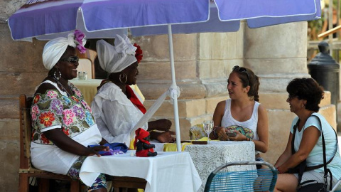 Dos turistas consultan su futuro con cartománticas en La Habana. Toparse con visitantes de Estados Unidos por La Habana es cada vez más habitual, atraídos por los coches antiguos que todavía circulan por su calles y sus edificaciones anteri Dos turistas consultan su futuro con cartománticas en La Habana. Toparse con visitantes de Estados Unidos por La Habana es cada vez más habitual, atraídos por los coches antiguos que todavía circulan por su calles y sus edificaciones anteri