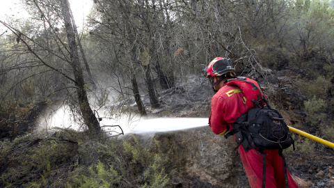 Un miembro de la UME refresca zonas quemadas en el perímetro del incendio de la Sierra de Espadán que ya ha quemado 1.400 hectáreas y ha sufrido hoy un pequeño rebrote en uno de sus frentes, a pesar de que la lluvia y el menor calor han ali Un miembro de la UME refresca zonas quemadas en el perímetro del incendio de la Sierra de Espadán que ya ha quemado 1.400 hectáreas y ha sufrido hoy un pequeño rebrote en uno de sus frentes, a pesar de que la lluvia y el menor calor han ali