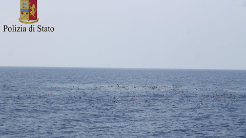 Inmigrantes supervivientes del naufragio de su barcaza, con 700 personas a bordo, nadando en el mar frente a las costas de Libia .-REUTERS /Policía de Italia