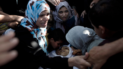Familiares y amigos de Baker Abu Nuqeira, un palestino asesinado en una explosión que destrozó una casa en el campo de refugiados de Al-Shabura, cerca de la ciudad de Rafah, llora sobre su cadáver durante su ceremonia fúnebre .-AFP PHOTO / 