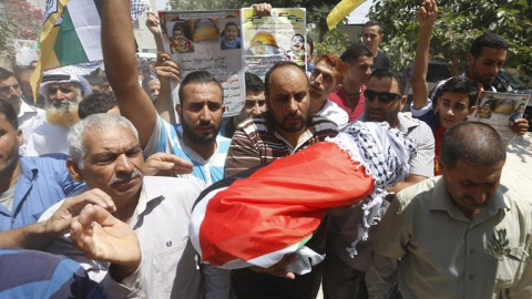 Un grupo de palestinos muestra el cuerpo sin vida de Ali Dawabsha, de 18 meses de vida, durante su funeral en Nablus (Cisjordania) hoy, 31 de julio de 2015. El secretario general de la Organización para la Liberación de Palestina (OLP) y je Un grupo de palestinos muestra el cuerpo sin vida de Ali Dawabsha, de 18 meses de vida, durante su funeral en Nablus (Cisjordania) hoy, 31 de julio de 2015. El secretario general de la Organización para la Liberación de Palestina (OLP) y je