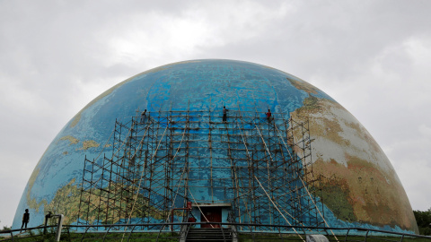 Un grupo de rabajadores elimina los andamios de una réplica del planeta tierra después de las reparaciones de la Ciudad de la Ciencia en Ahmedabad, India. REUTERS/Amit Dave