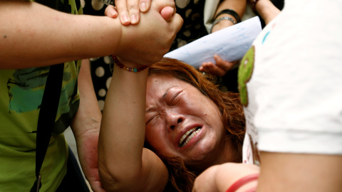 La familiar de un pasajero que viajaba a bordo del vuelo MH370 de Malaysia Airlines, que desapareció en 2014 reacciona durante una protesta frente al Ministerio de Asuntos Exteriores chino en Pekín. REUTERS/Thomas Peter