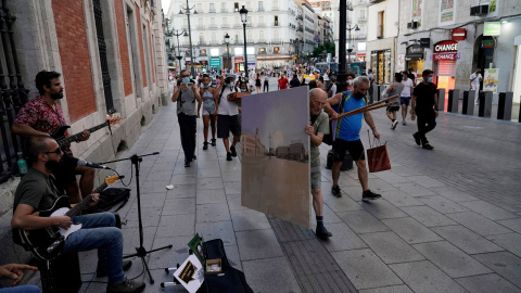 El pintor Antonio López lleva el lienzo en el que está pintando la Puerta del Sol de Madrid después de una jornada de trabajo en la misma plaza. REUTERS / Juan Medina El pintor Antonio López lleva el lienzo en el que está pintando la Puerta del Sol de Madrid después de una jornada de trabajo en la misma plaza. REUTERS / Juan Medina