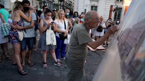 Varias personas observan trabajar al pintor Antonio Lopez en la céntrica Puerta del Sol de Madrid. REUTERS/Juan Medina Varias personas observan trabajar al pintor Antonio Lopez en la céntrica Puerta del Sol de Madrid. REUTERS/Juan Medina