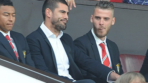 El portero del Manchester United David De Gea junto a su compañero Victor Valdes, en la grada del estadio  Old Trafford, durante el primer partido de la Premier League británica. EFE/EPA/PETER POWELL