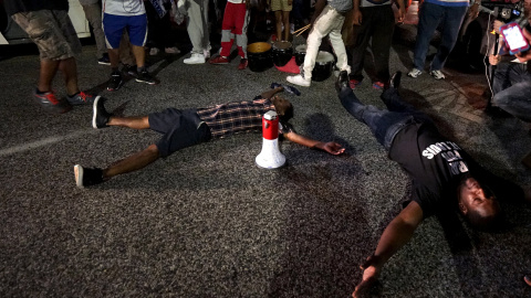 Dos jóvenes se tumban en el suelo para simular el asesinato, hace un año, del afroamericano Michael Brown. REUTERS / Rick Wilking