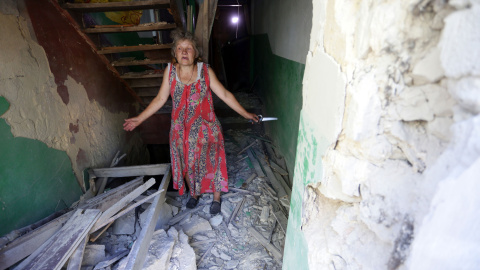 Una mujer dentro de su casa destruida como consecuencia de los bombardeos entre las fuerzas ucranianas y los separatistas pro-rusos el 10 de agosto de 2015, de la aldea Golmovsky, región de Donetsk. ALEKSEY FILIPPOV / AFP