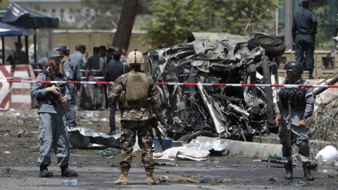 Miembos de los servicios de seguridad afganos inspeccionan el lugar donde un conductor suicida hizo detonar los explosivos que portaba en su coche, en el control de seguridad del aeropuerto Internacional de Kabul, Afganistán, hoy, 10 de ago